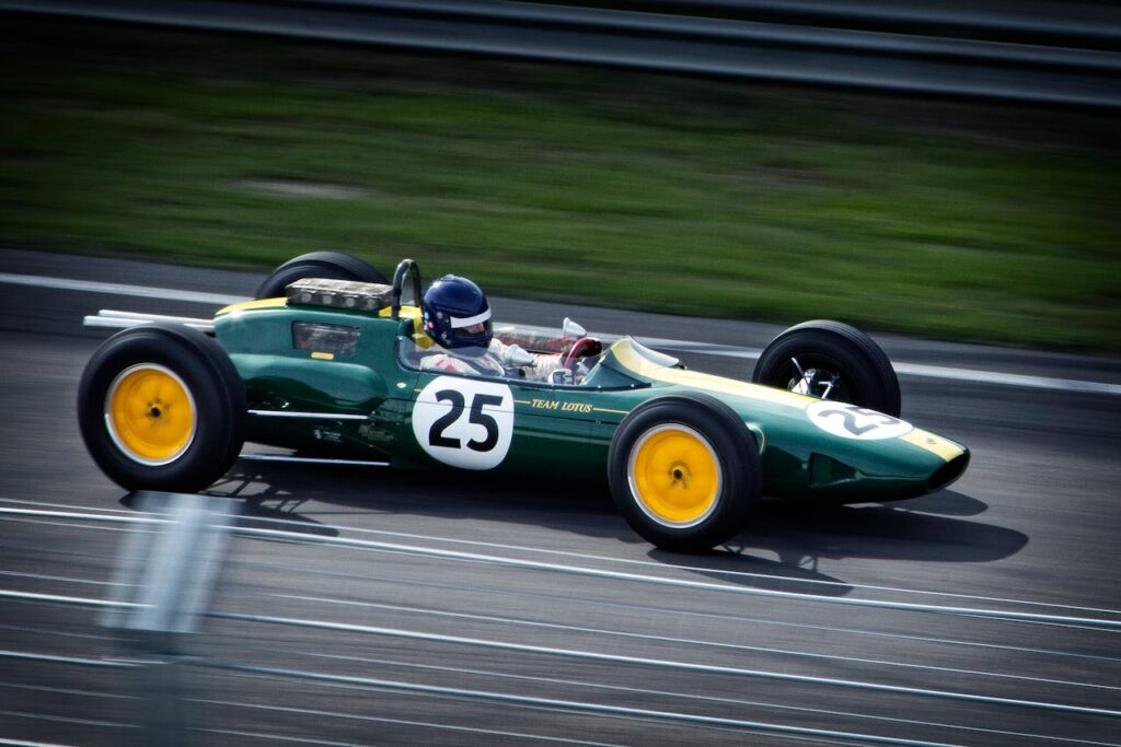 pexels-photo-12801 A green vintage Formula 1 car with number 25 speeds around a racetrack, showcasing classic racing heritage.